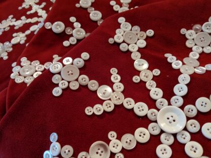 Red velvet with white antique buttons in the design of a snowflake